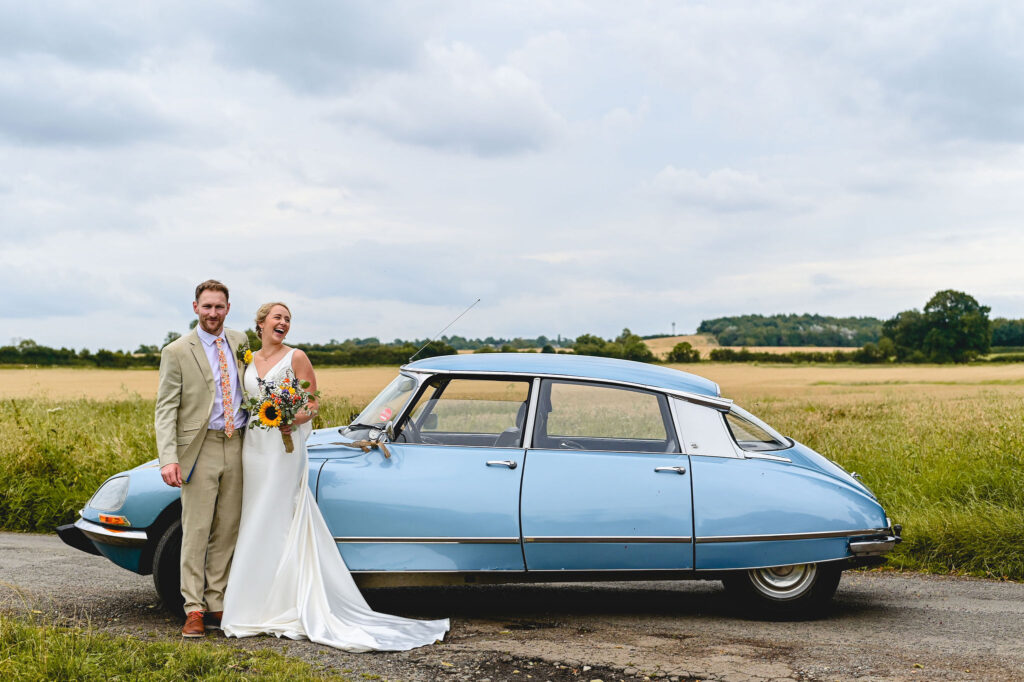 Wedding couple in front of blue car near Market Harborough, Leicestershire