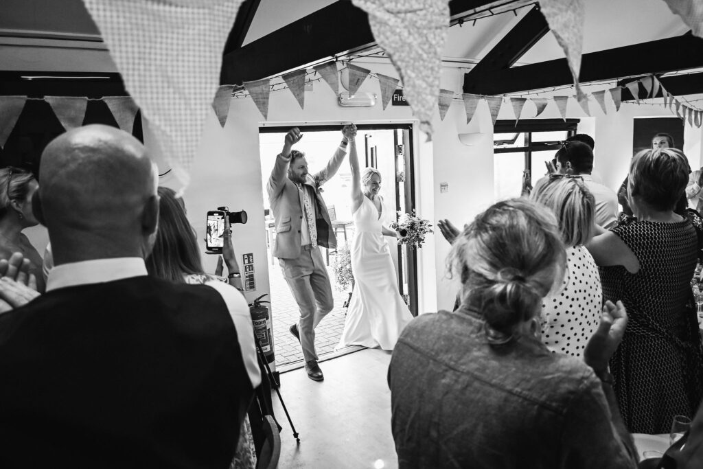 Wedding couple walking into reception in Market Harborough Rugby Club, Leicestershire